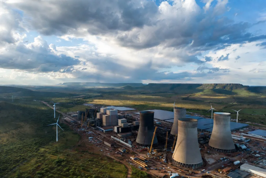Aerial landscape of Hendrina Power Station area showing transition from coal infrastructure to green energy storage facilities. Aerial landscape of Hendrina Power Station area showing transition from coal infrastructure to green energy storage facilities.